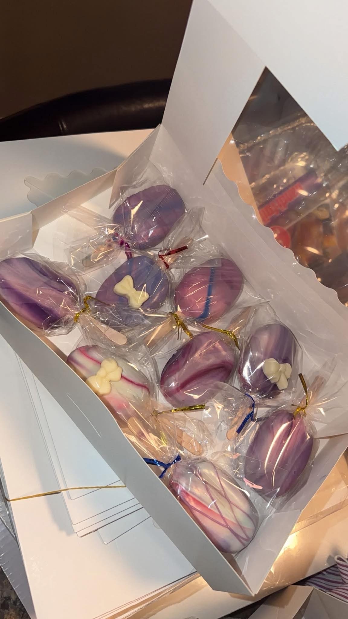 Box of marbled purple heart-shaped chocolate lollipops